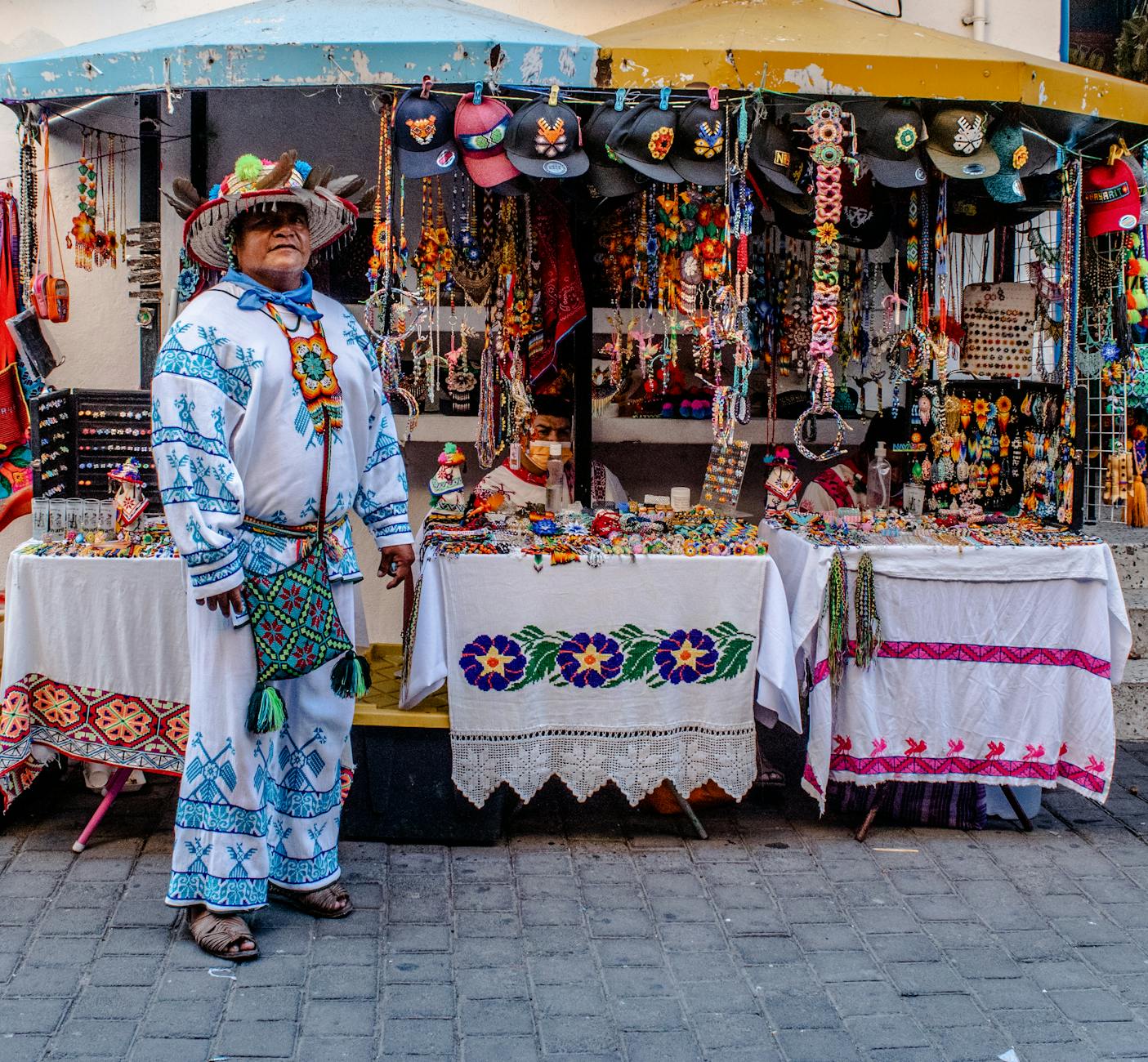 A colourful outdoor market stall with handmade crafts and products