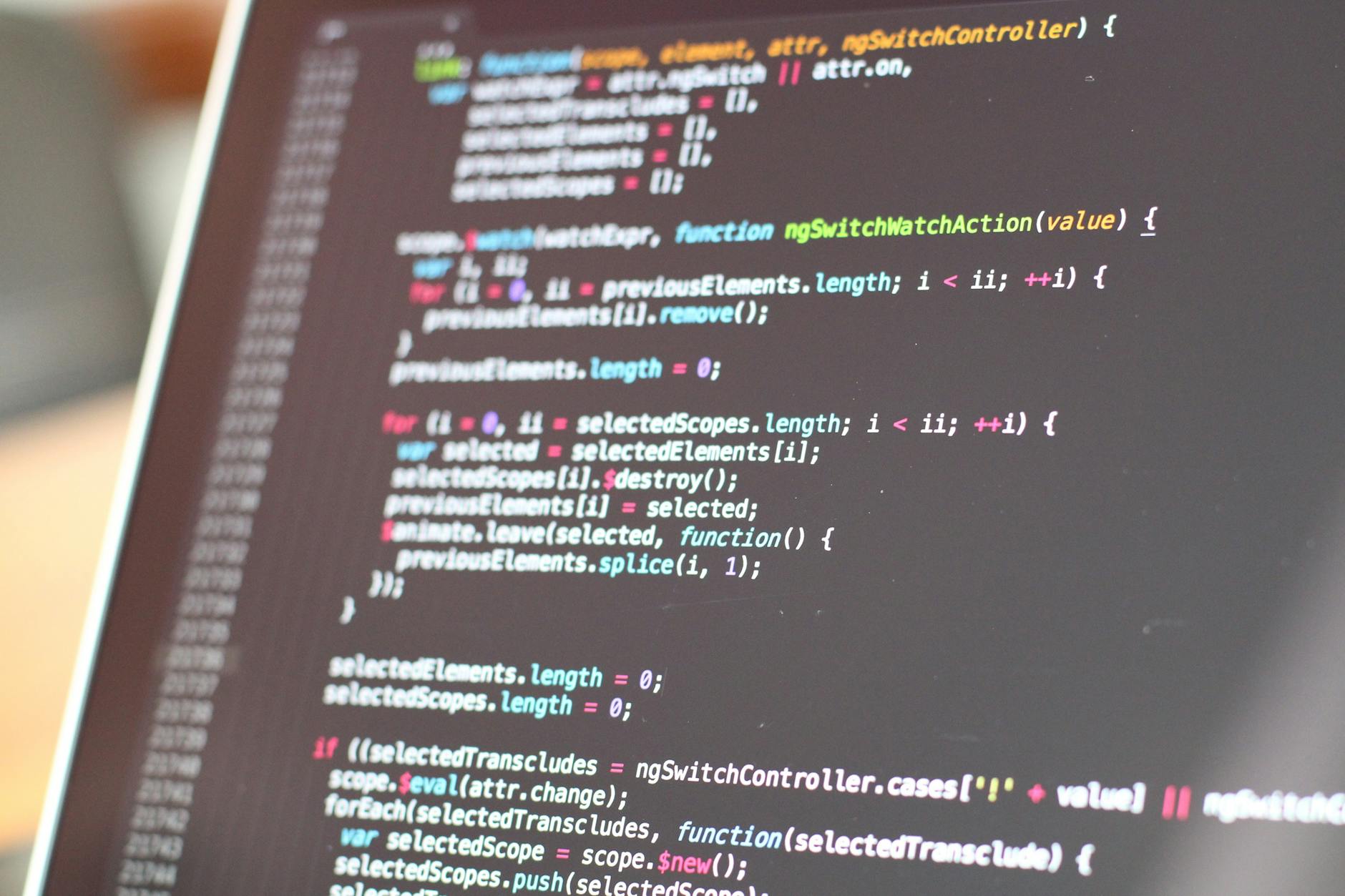 Developer working on laptop with code on the screen