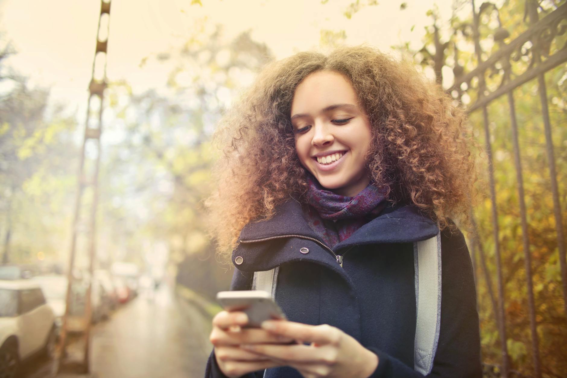 Person using a mobile phone to browse a website outdoors