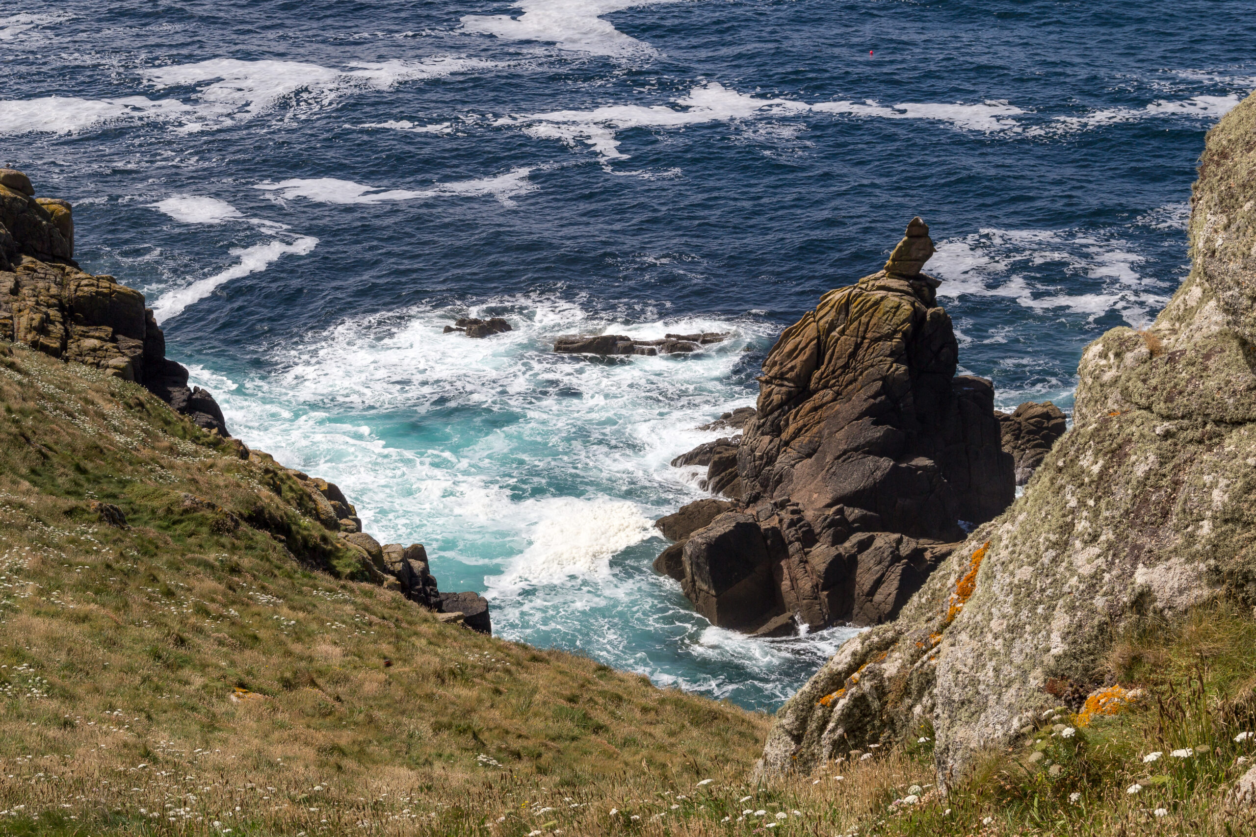 Person walking along a Cornwall coastal path in a mindful setting