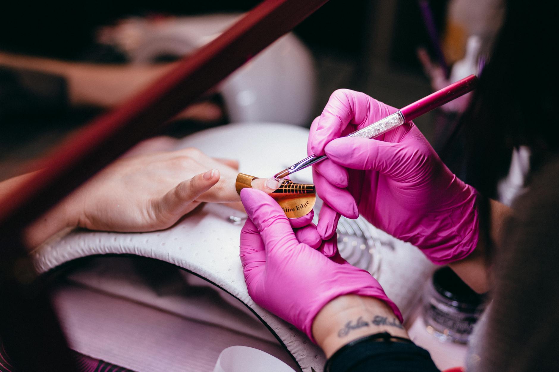 Nail technician applying nail art to a client
