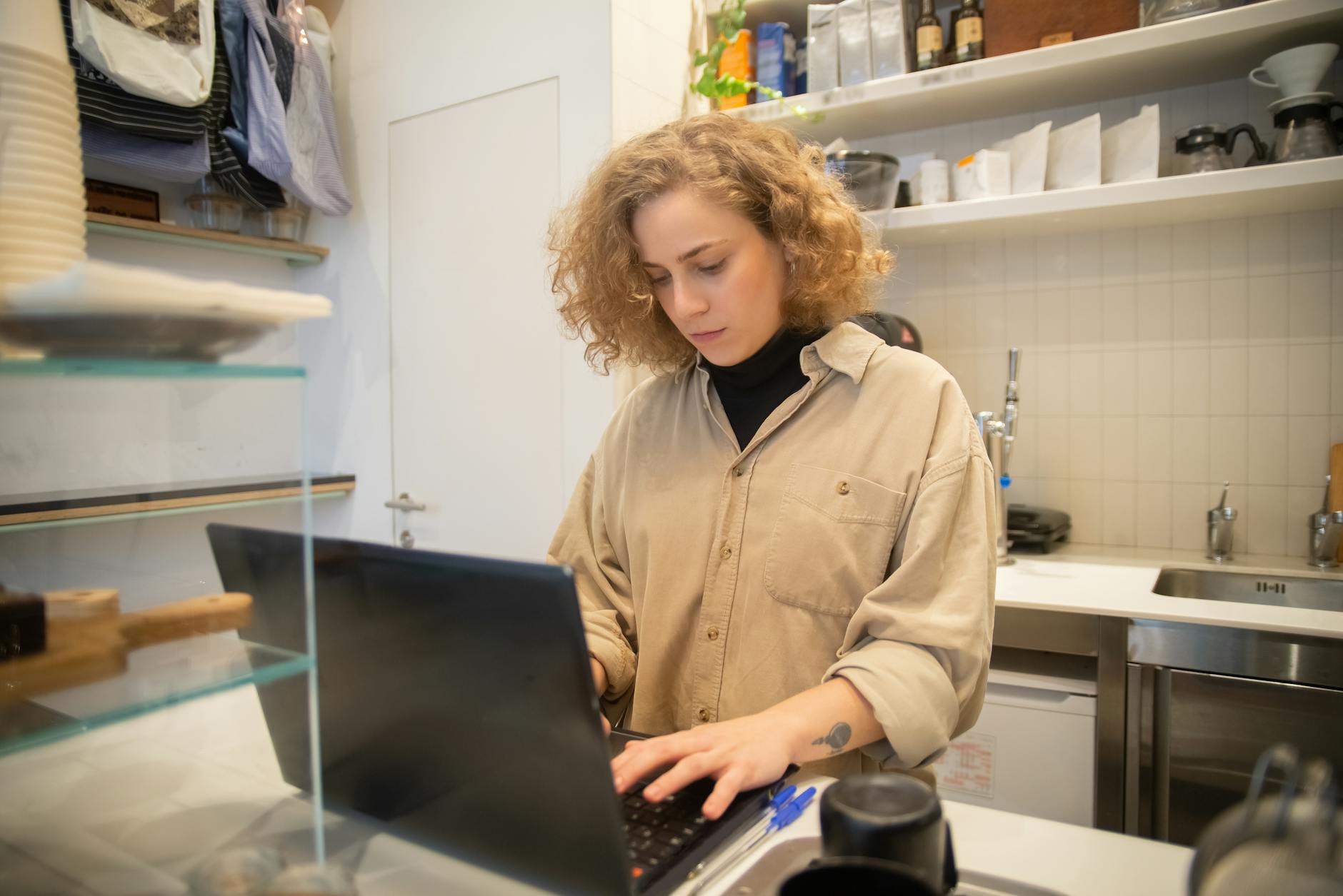 Small business owner working on a laptop in a Cornwall cafe