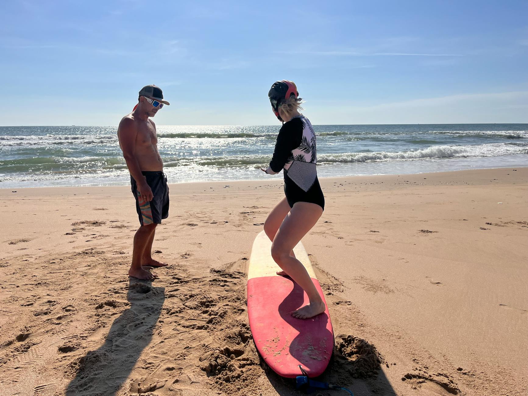 Surf instructor teaching a beginner lesson on a Cornwall beach
