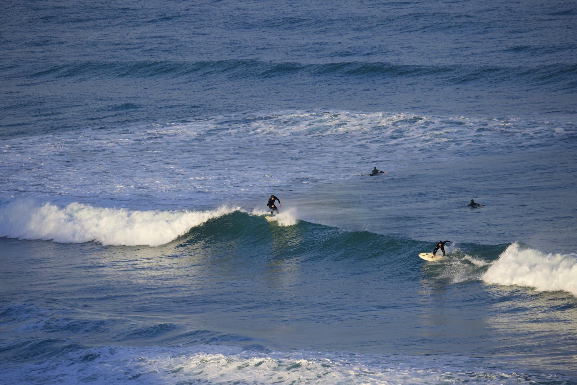 Surfers riding waves at Fistral beach in Newquay Cornwall