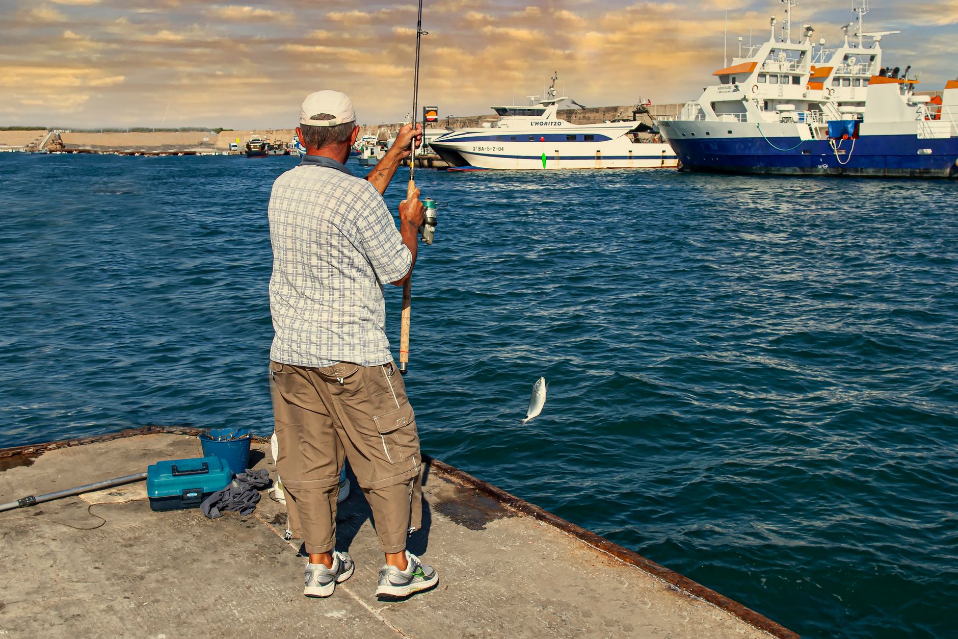 Angler holding a rod with a catch on a deep sea fishing trip