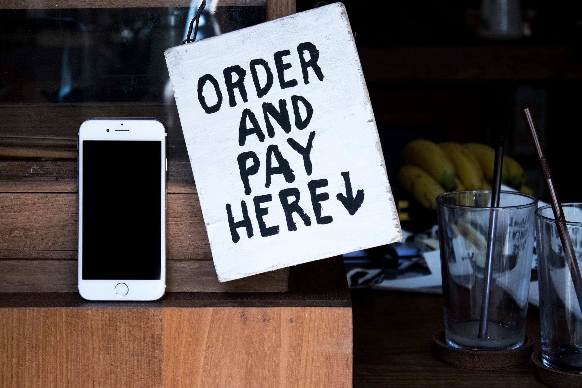 Customer leaving a review on a smartphone in a cafe