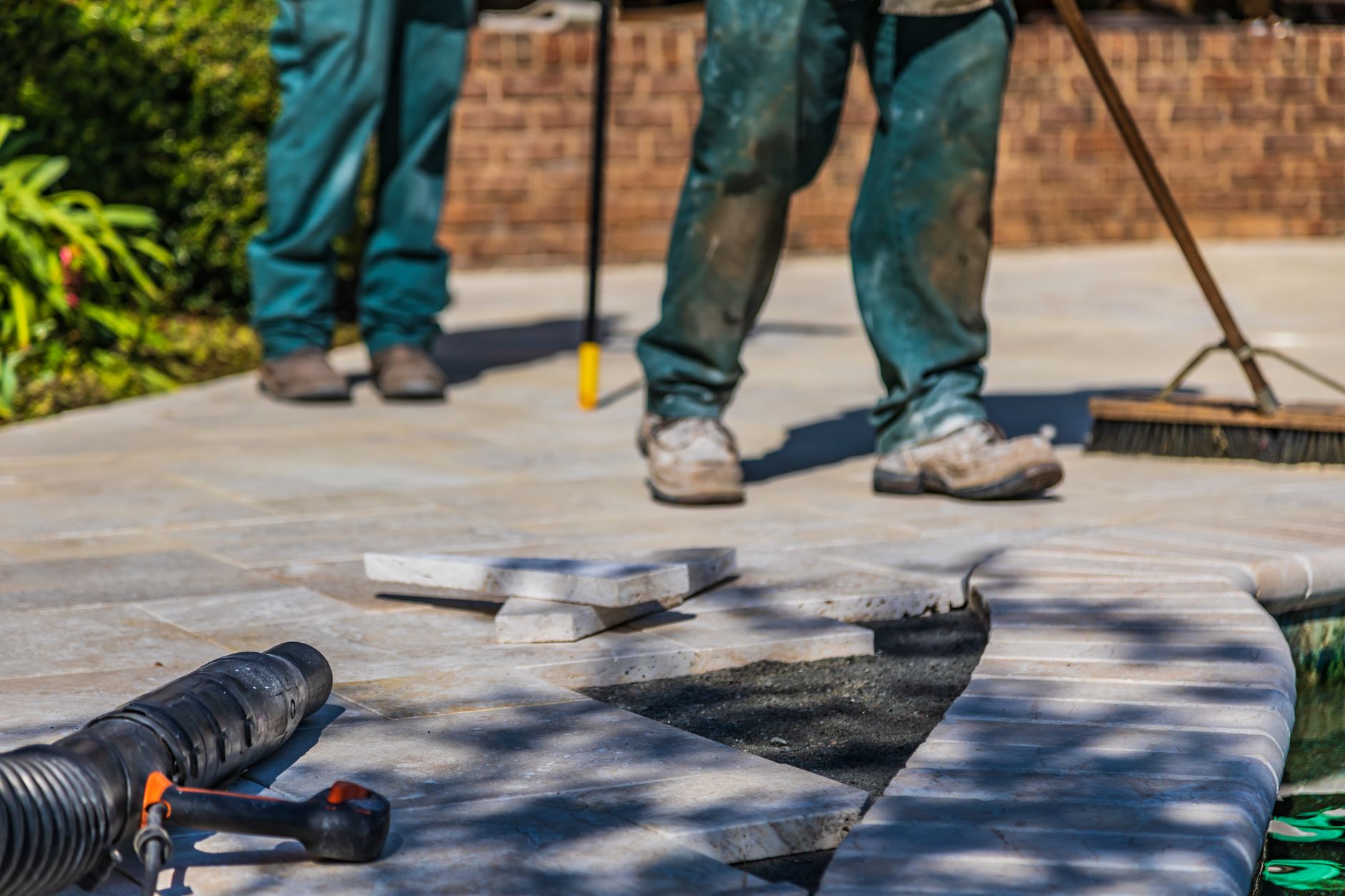Landscaper laying patio stones in a garden