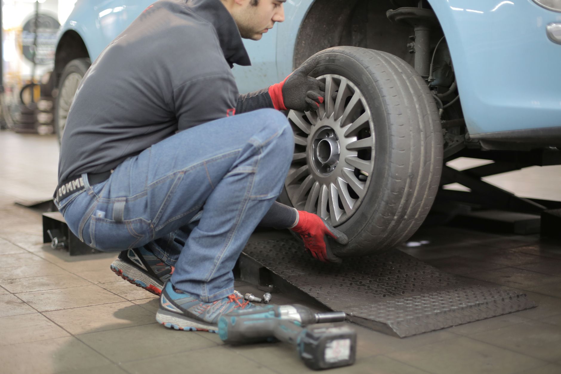 Mechanic changing a car tyre in a workshop