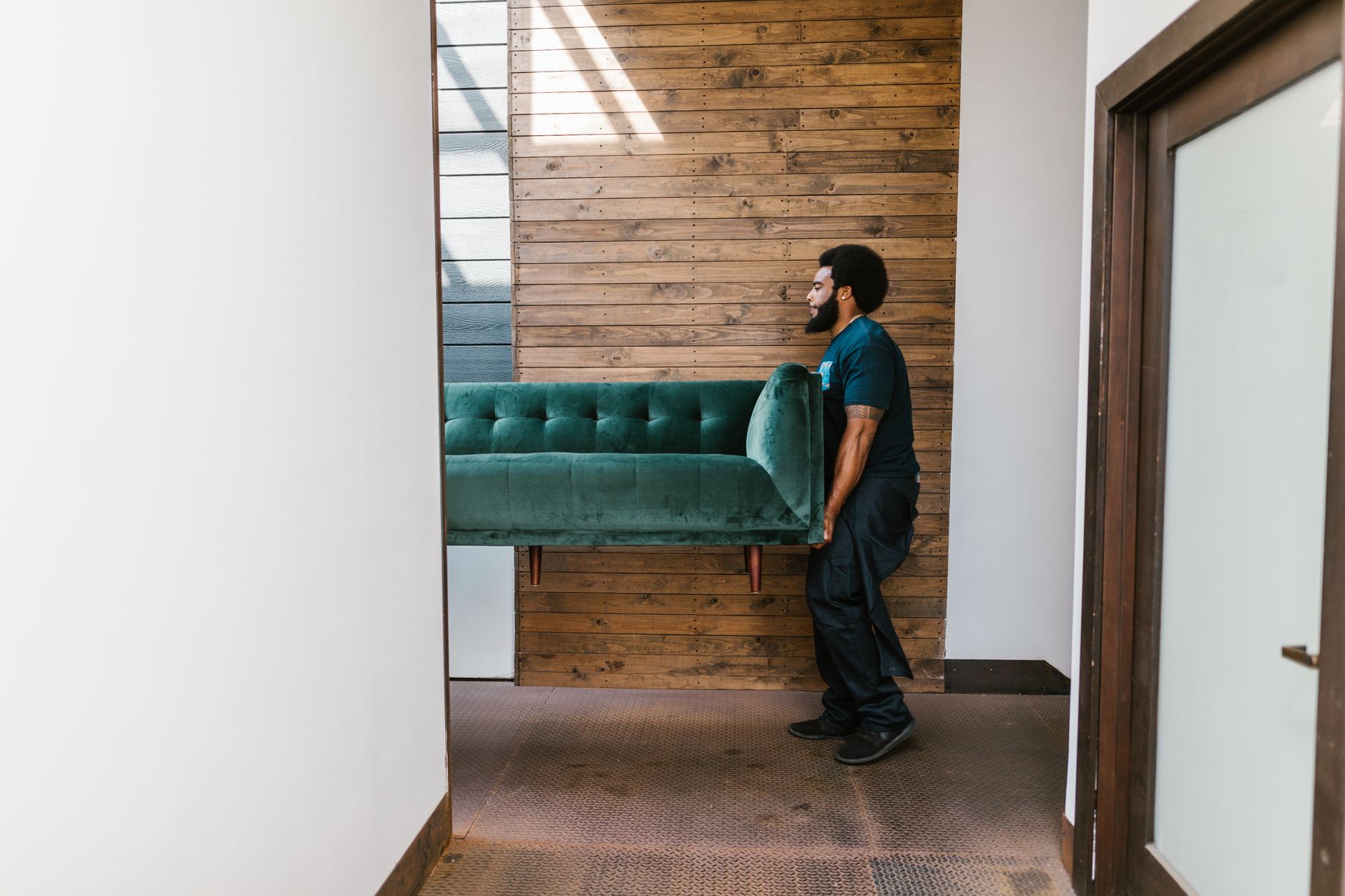 Removal team carrying furniture into a house