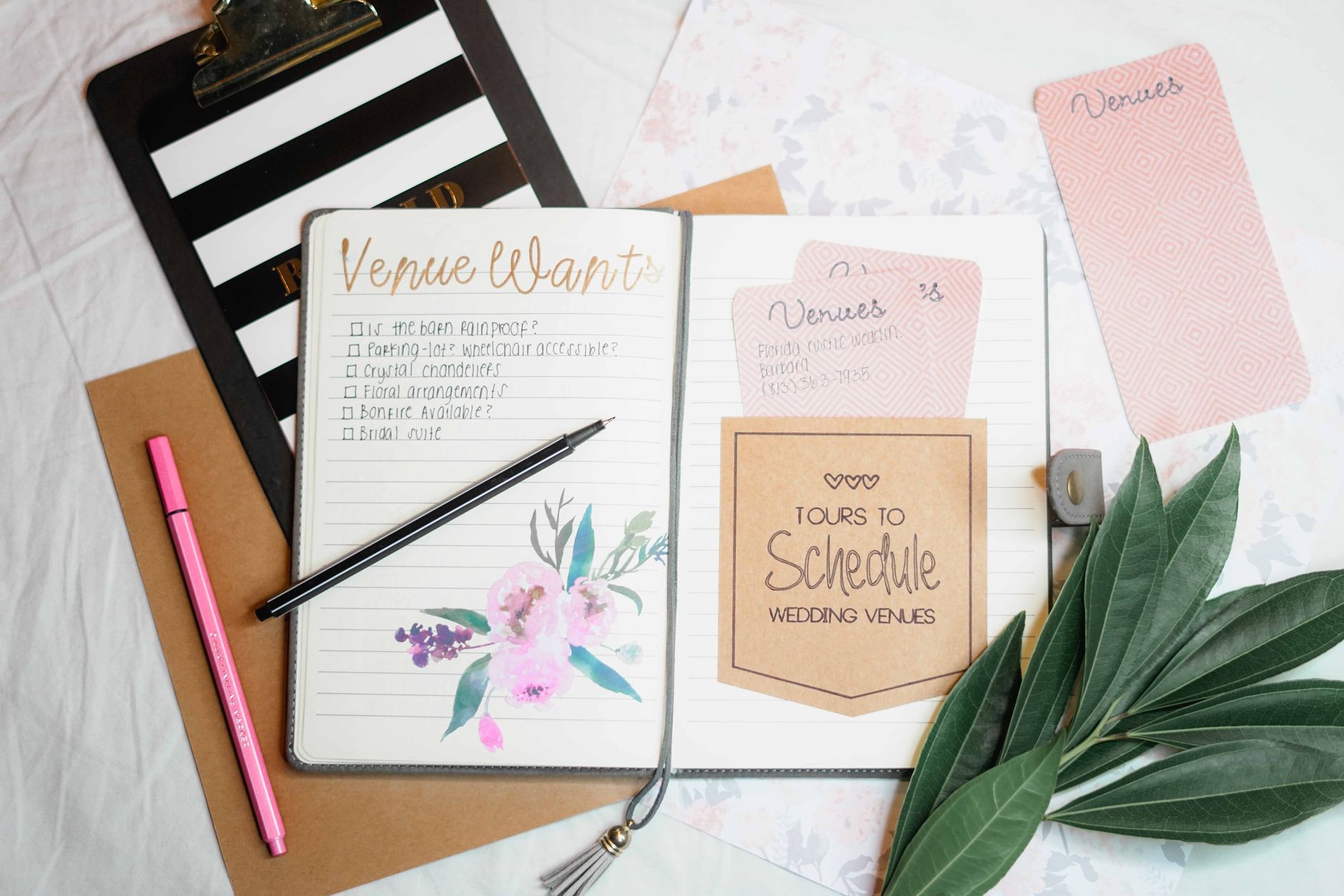 Wedding planner with a clipboard at a venue during styling