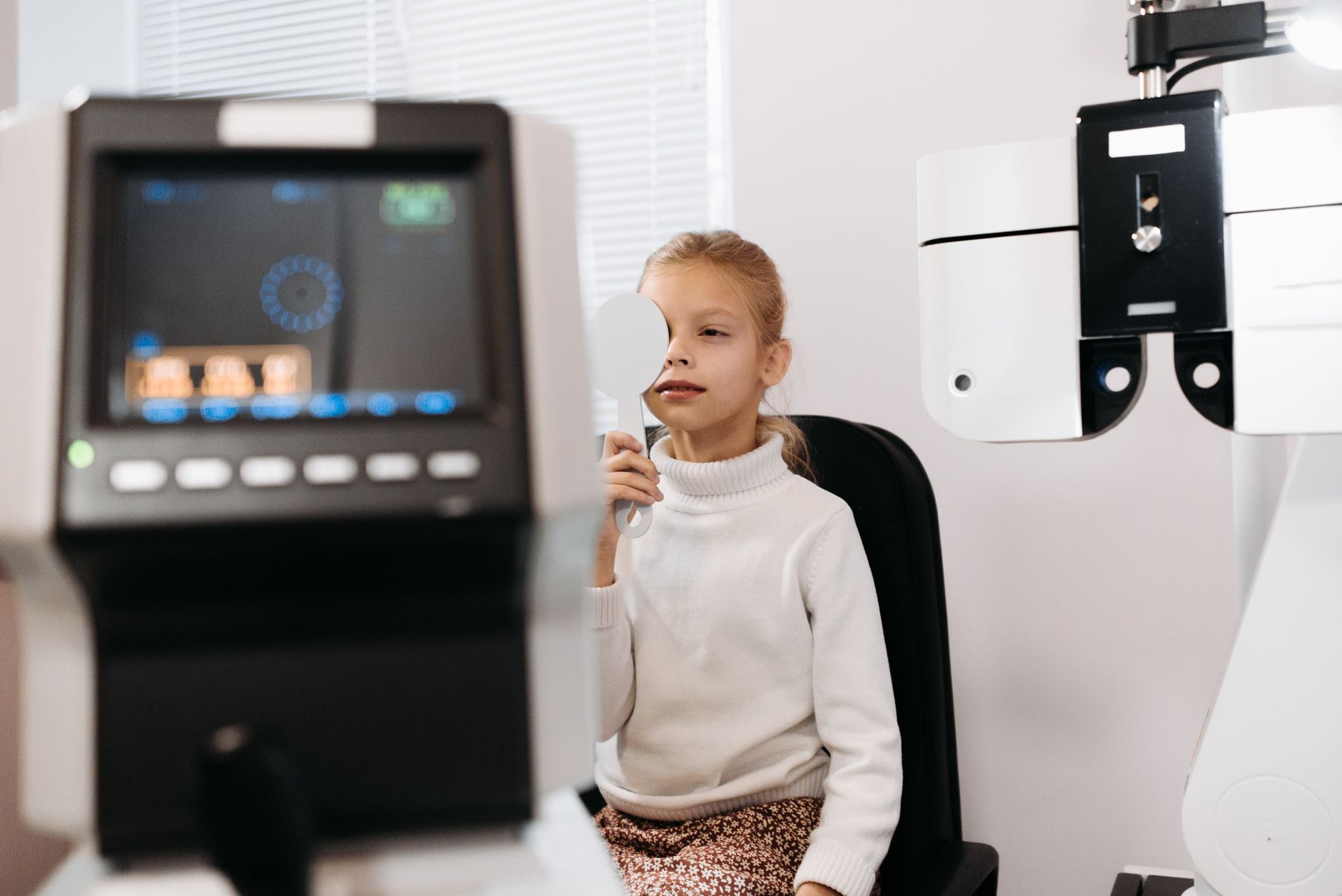Child having an eye test carried out by an optician