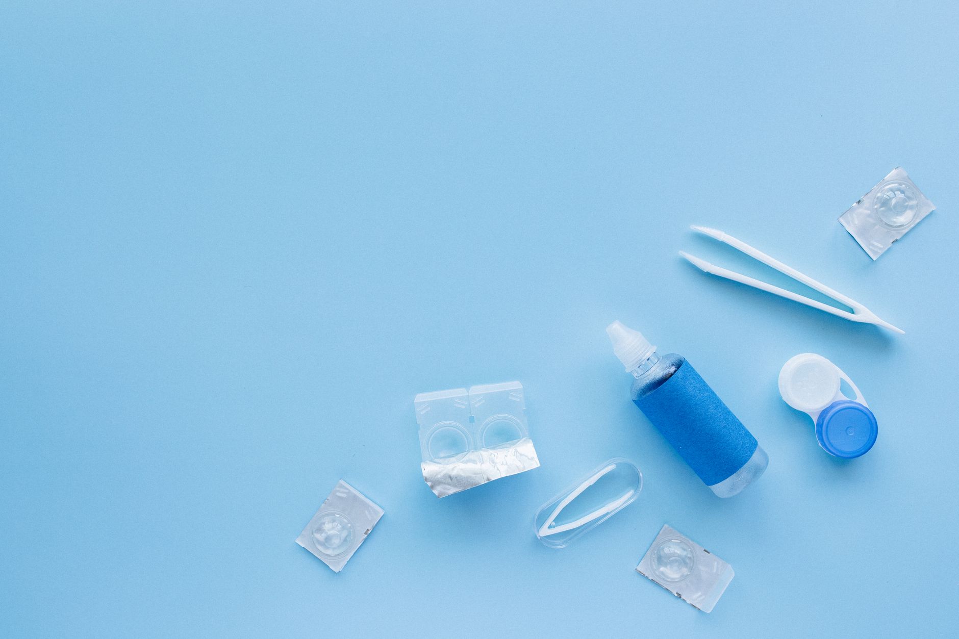 Contact lenses next to a case and cleaning solution