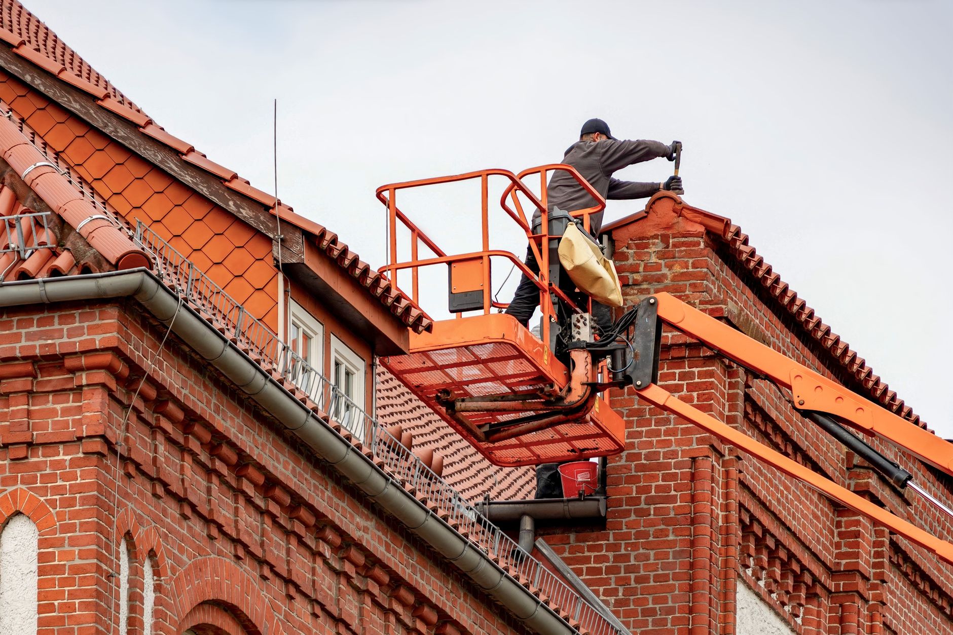 Roofer repairing tiles on a residential roof