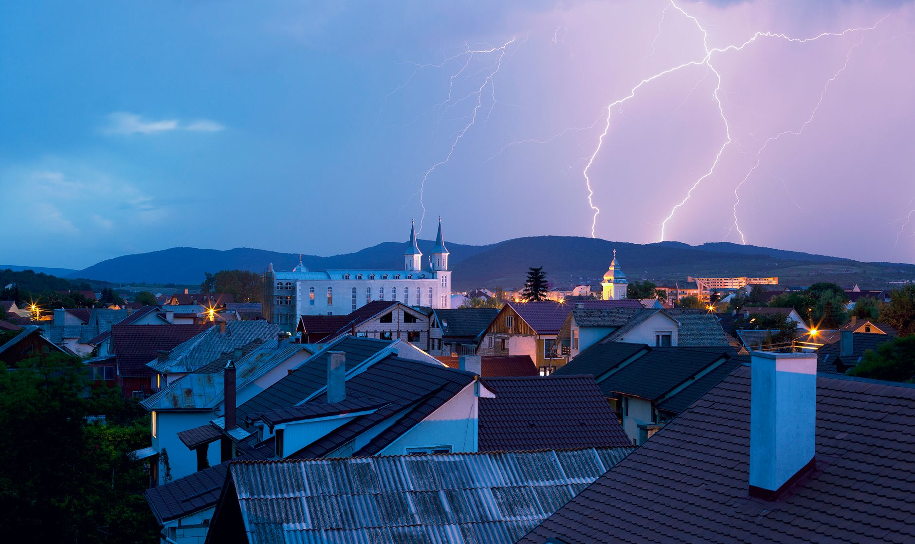 Storm clouds gathering over rooftops in a coastal town