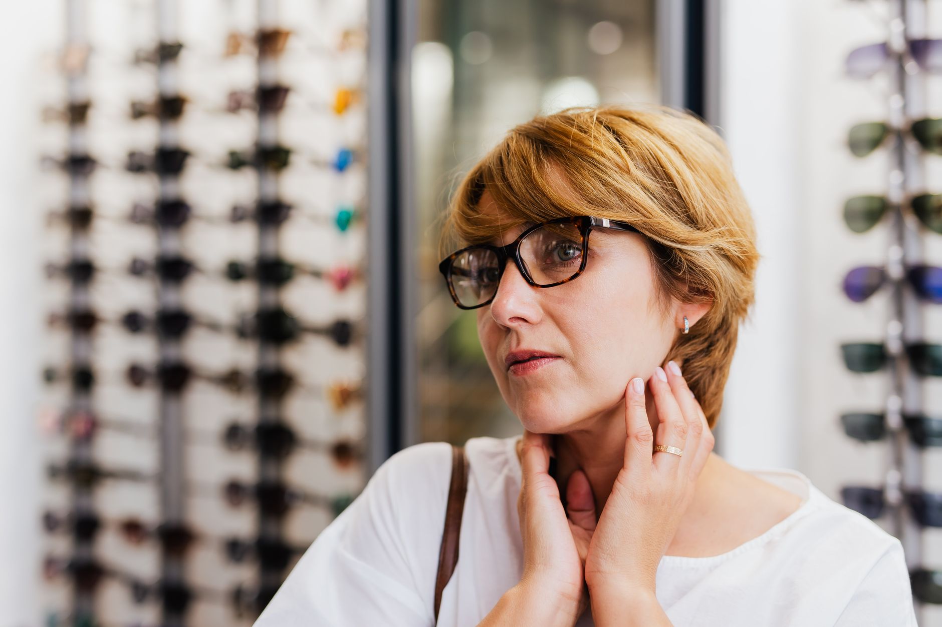 Woman trying on a pair of glasses in an optician store